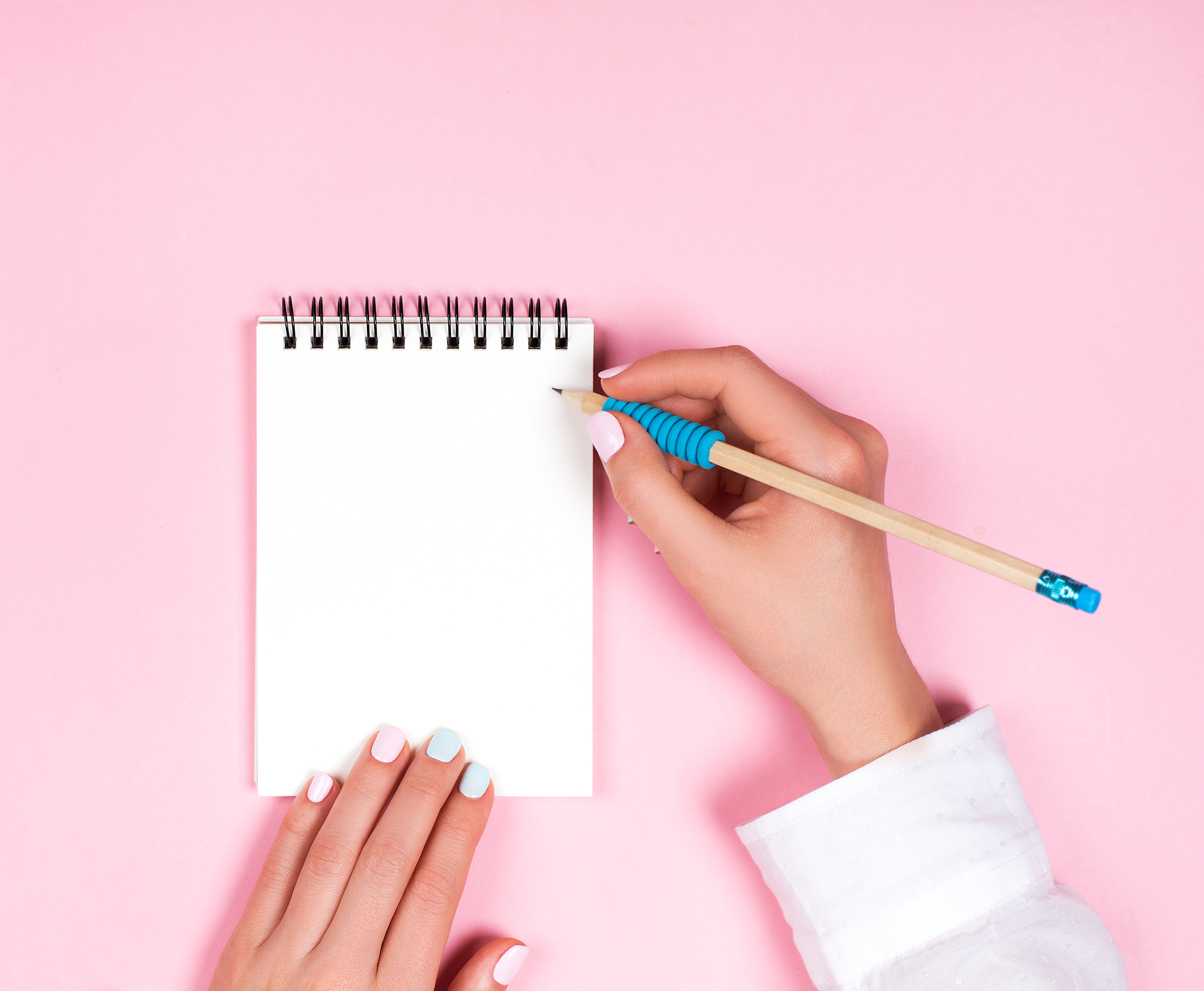 A woman taking notes in her journal while she drinks coffee